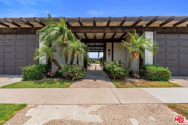 doorway to property with a garage and a carport