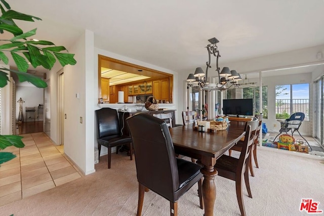 dining space featuring a chandelier and light colored carpet