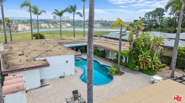 view of swimming pool with a water view and a patio