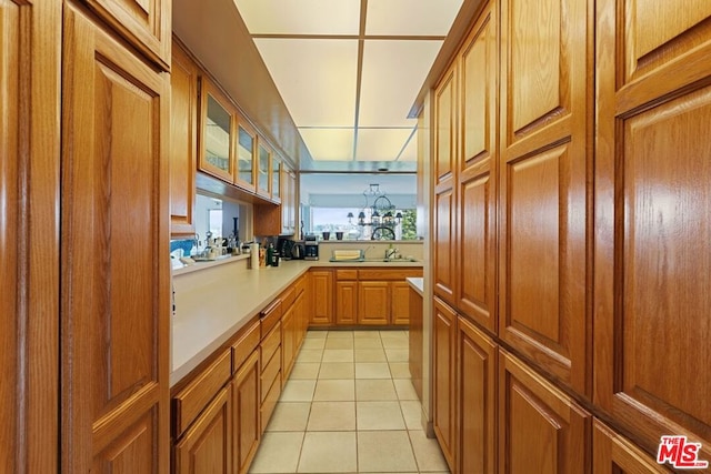 kitchen featuring kitchen peninsula, hanging light fixtures, a notable chandelier, and light tile patterned floors