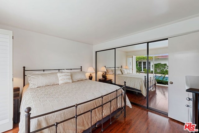 bedroom featuring ornamental molding, a closet, and dark hardwood / wood-style flooring