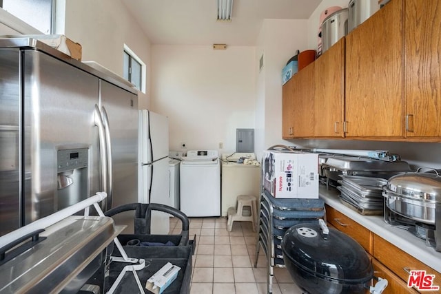 kitchen with independent washer and dryer, light tile patterned floors, stainless steel fridge with ice dispenser, and a wealth of natural light