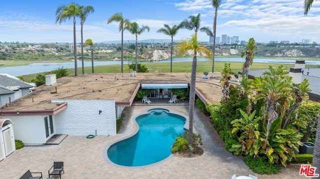 view of swimming pool with a water view and a patio area