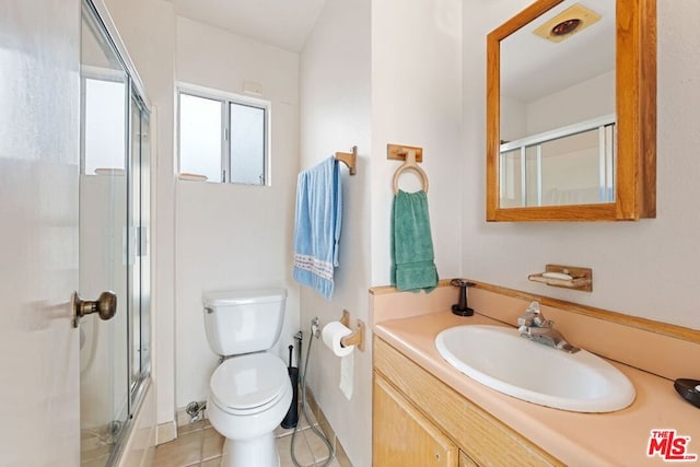 bathroom featuring walk in shower, vanity, tile patterned flooring, and toilet