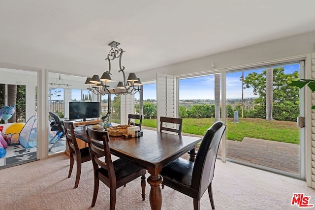 dining room with light carpet and a notable chandelier