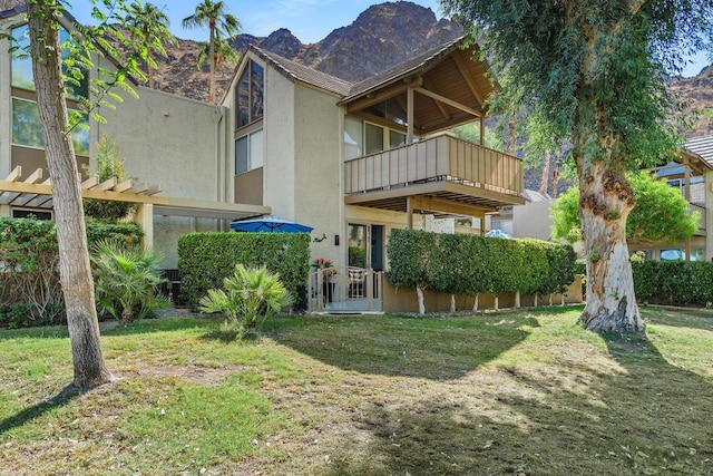 rear view of property featuring a mountain view and a yard