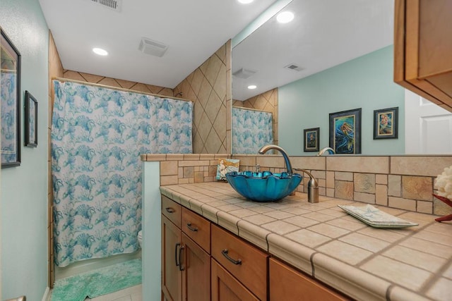 bathroom with toilet, vanity, decorative backsplash, and a shower with curtain