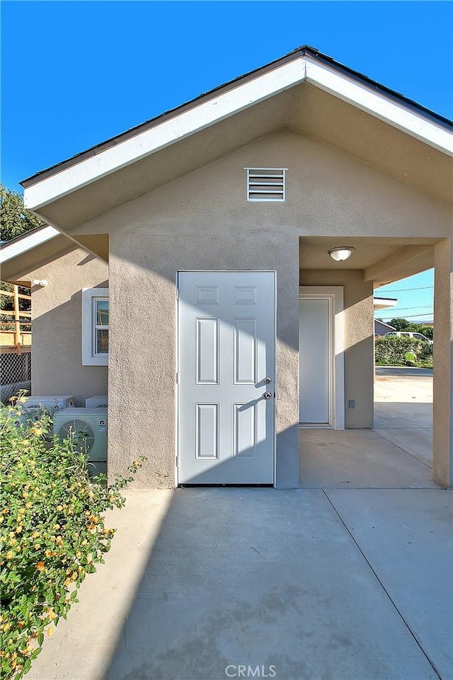 view of exterior entry with a patio