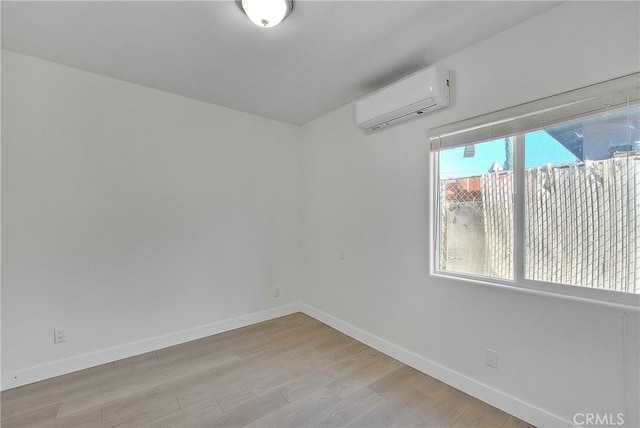 unfurnished room featuring light hardwood / wood-style floors and a wall unit AC