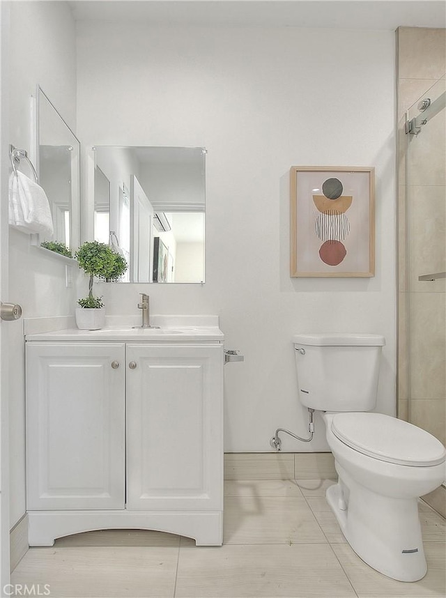 bathroom with a shower with door, vanity, and toilet