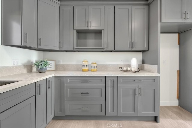 kitchen featuring light wood-type flooring and gray cabinets