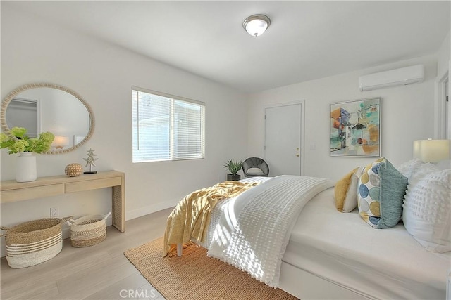 bedroom featuring light hardwood / wood-style floors and a wall mounted AC