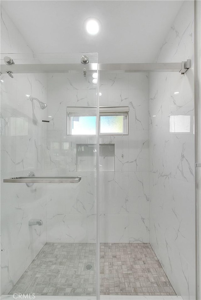 bathroom with a shower with door