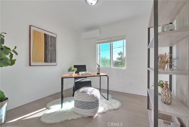 office area with light hardwood / wood-style flooring and a wall unit AC