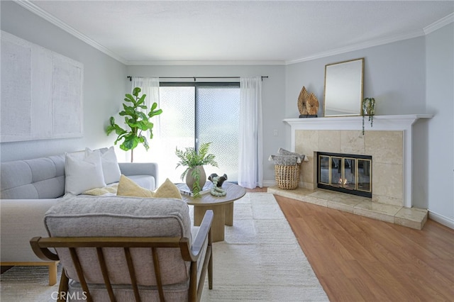 living room with crown molding, light hardwood / wood-style floors, and a tiled fireplace