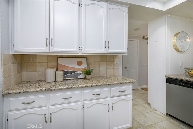 kitchen with light stone countertops, white cabinets, backsplash, and dishwasher