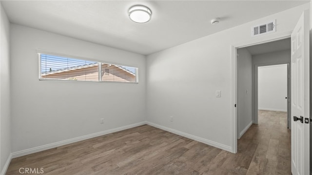 unfurnished room with hardwood / wood-style flooring