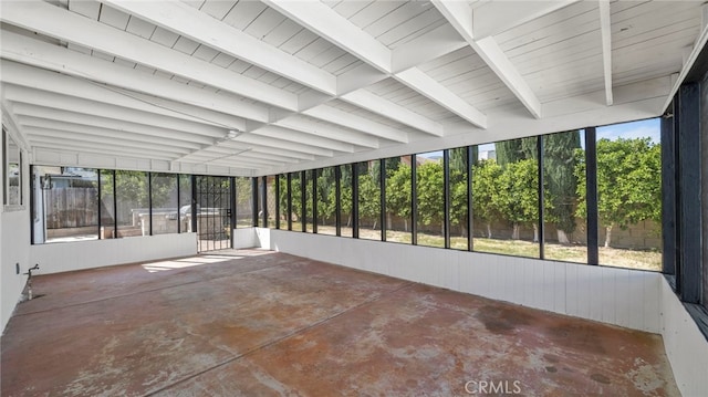 unfurnished sunroom with plenty of natural light and beam ceiling