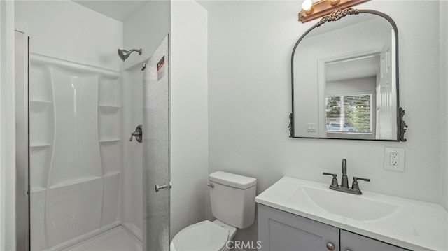 bathroom featuring walk in shower, vanity, and toilet