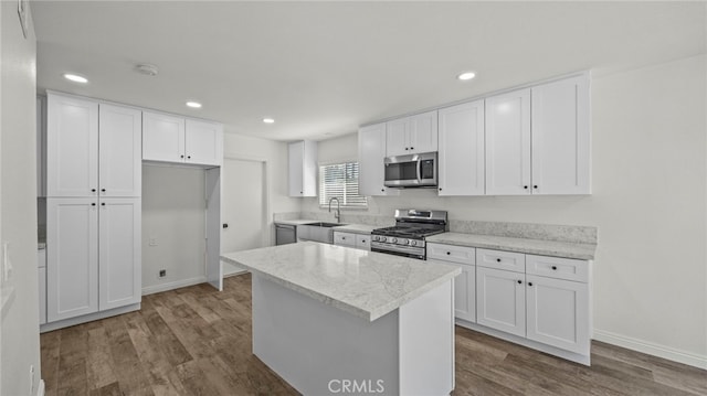 kitchen with wood-type flooring, white cabinetry, sink, and stainless steel appliances