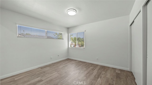 unfurnished bedroom with a closet and light hardwood / wood-style flooring