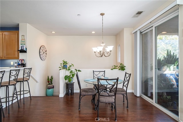 dining space featuring dark wood-type flooring and a chandelier