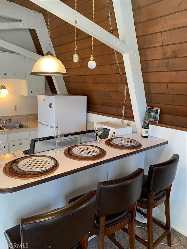 dining area with wooden walls and sink