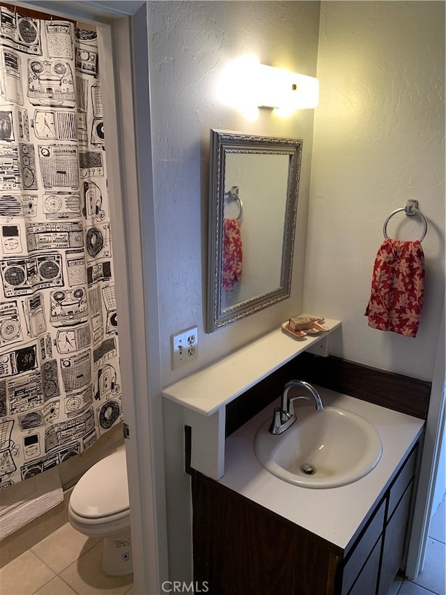 bathroom featuring toilet, tile patterned flooring, vanity, and curtained shower