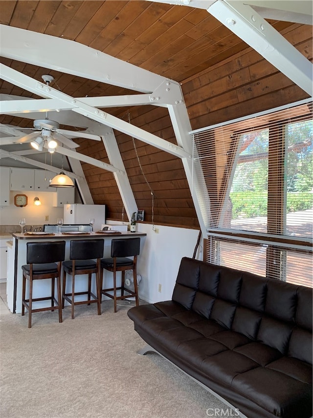 living room featuring ceiling fan, vaulted ceiling with beams, wooden ceiling, and light colored carpet