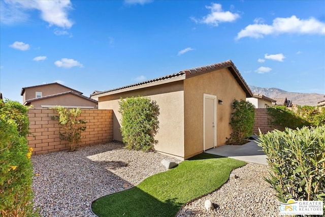 view of home's exterior with a mountain view and a patio area