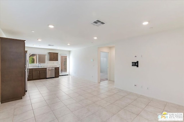 unfurnished living room featuring sink and light tile patterned floors