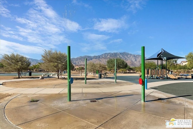 surrounding community with a playground and a mountain view