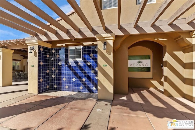 entrance to property with a pergola