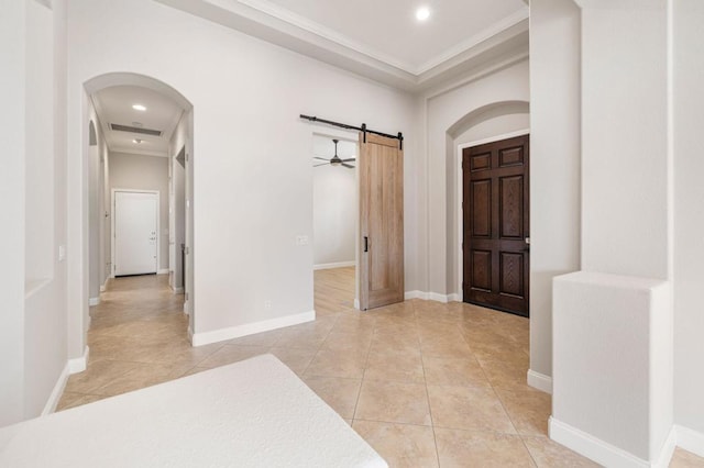 tiled foyer entrance featuring crown molding and a barn door