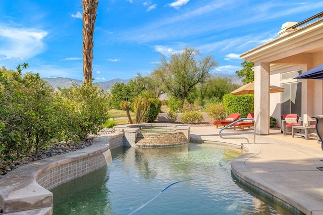 view of swimming pool with a mountain view, a patio, and an in ground hot tub