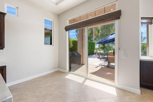 doorway with plenty of natural light and light tile patterned floors