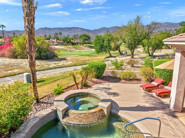 exterior space with a mountain view, a patio, and an in ground hot tub