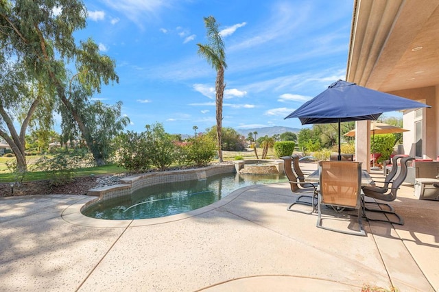 view of swimming pool featuring an in ground hot tub, a mountain view, and a patio