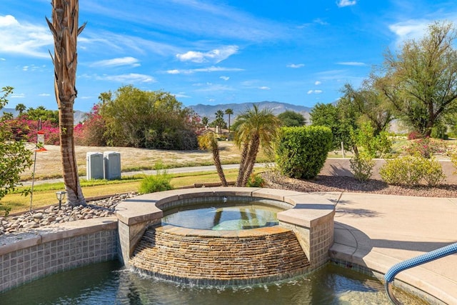 view of patio with a mountain view and an in ground hot tub