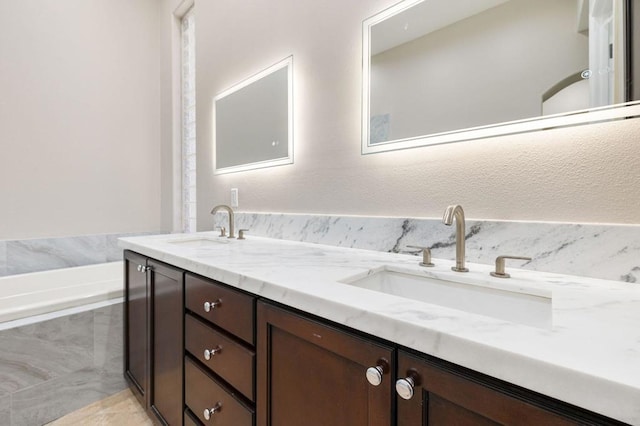 bathroom featuring vanity and tiled bath