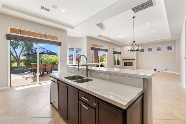 kitchen with a raised ceiling, sink, dark brown cabinetry, and a chandelier