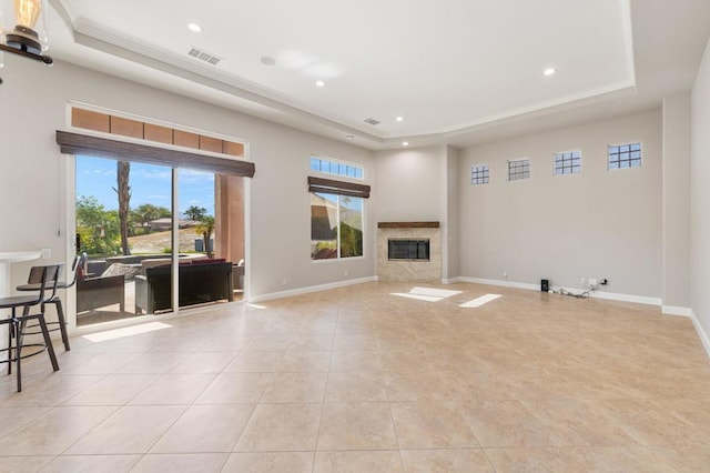 tiled living room featuring a high end fireplace, a tray ceiling, and a high ceiling