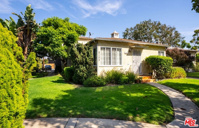 bungalow-style home featuring a front lawn and central air condition unit