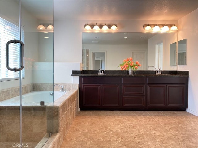 bathroom featuring vanity and a relaxing tiled tub