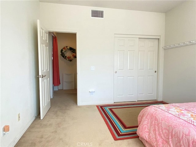 bedroom featuring light carpet and a closet