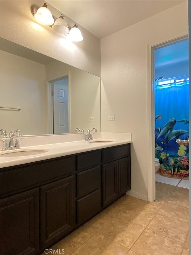 bathroom with tile patterned flooring, vanity, and toilet