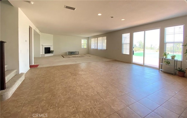 unfurnished living room with a healthy amount of sunlight and light tile patterned floors