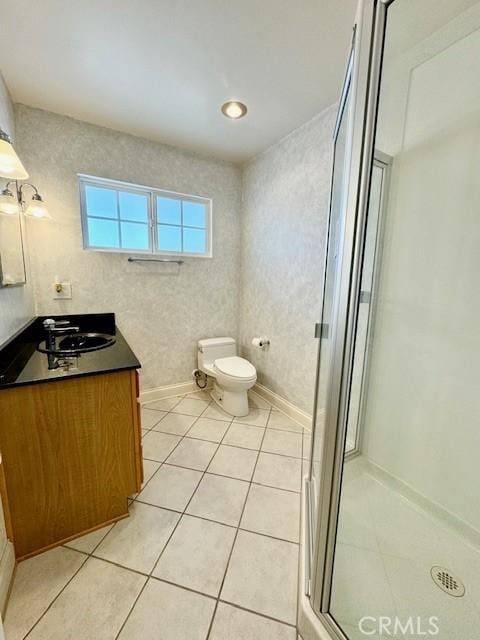 bathroom featuring tile patterned floors, vanity, toilet, and walk in shower