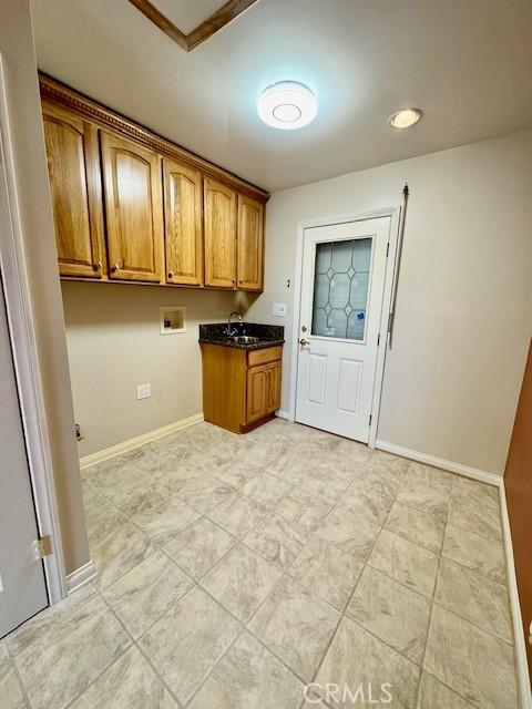 washroom featuring washer hookup, cabinets, and sink