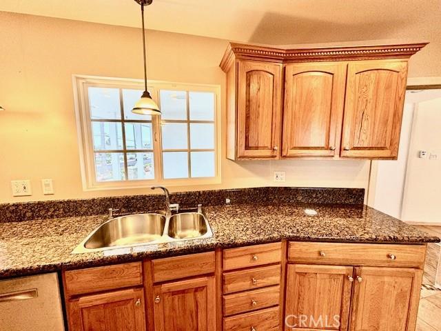 kitchen with pendant lighting, sink, and dark stone counters